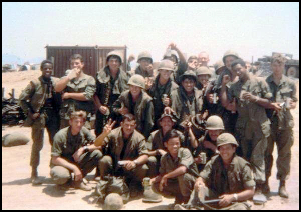 Photo of Corporal Johhny L. Moore, U.S. Army (far lieft, standing), with some members of his unit and their South Vietnamese counterparts, unknown date.